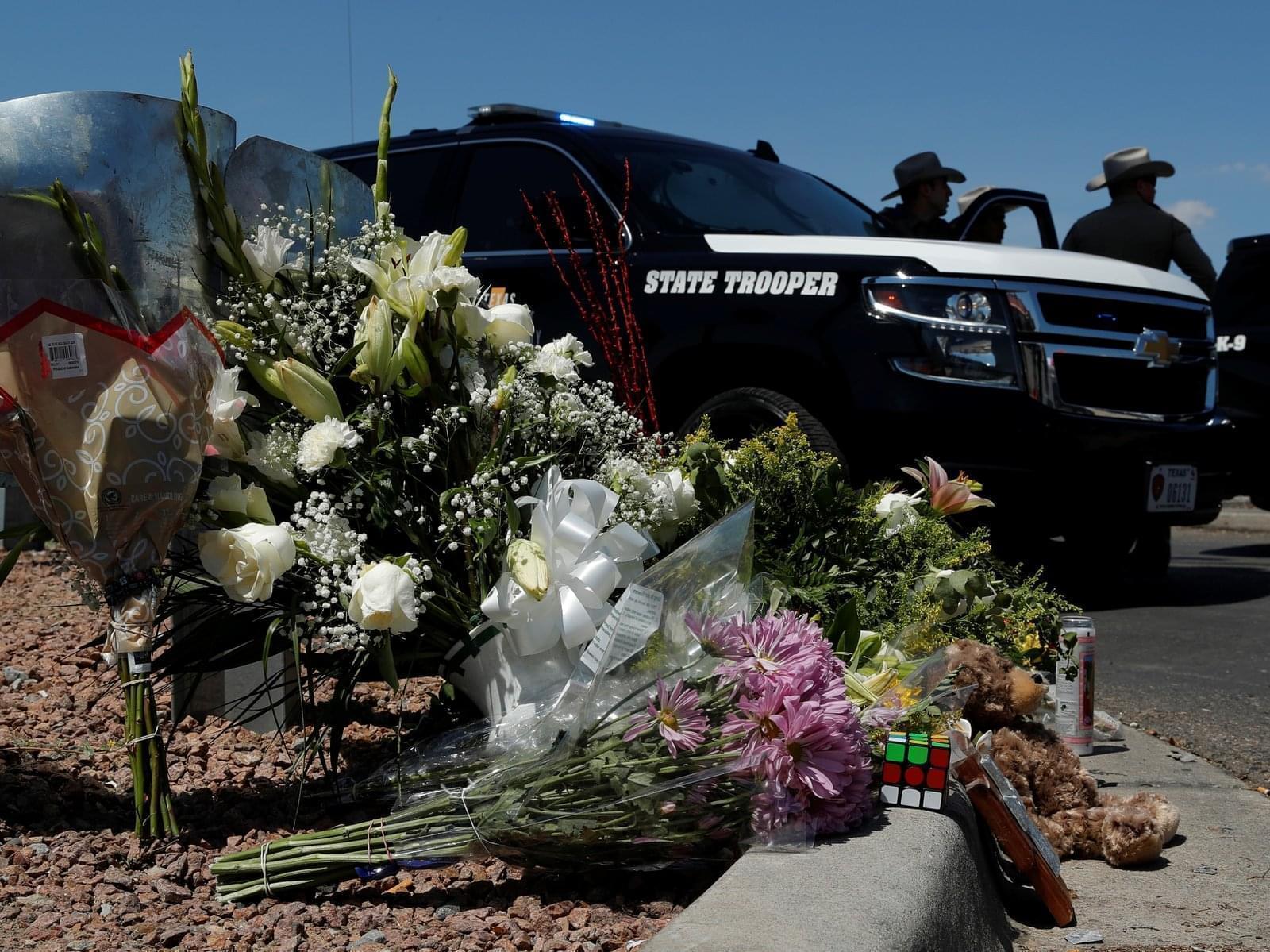 Flowers adorn a makeshift memorial near the scene of a mass shooting at a shopping complex Sunday in El Paso, Texas.
