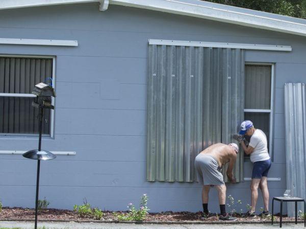People in Vero Beach, Fla., install shutters on their home on Thursday in preparation for Hurricane Dorian, now expected to be a Category 4 storm when it hits the U.S. coastline.