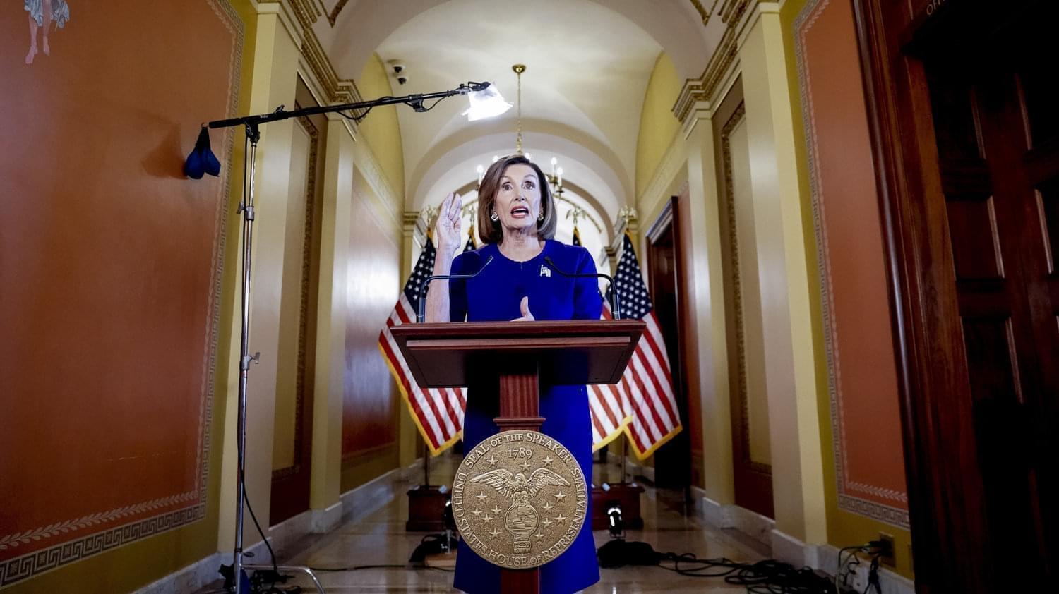 House Speaker Nancy Pelosi behind a podium.