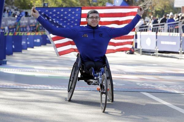 Daniel Romanchuk poses and American flag after winning the men's wheelchair division of the New York City Marathon.