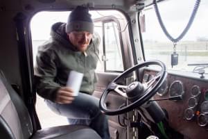 Central Iowa farmer Corey Hillebo climbs into the cab of his semi after picking up the receipt for corn he delivered to a grain elevator. 