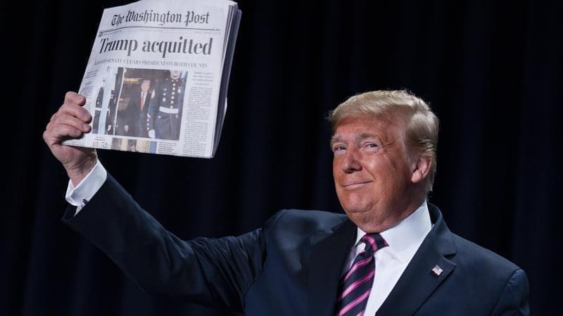 President Trump holds up Thursday's Washington Post with the headline "Trump acquitted."