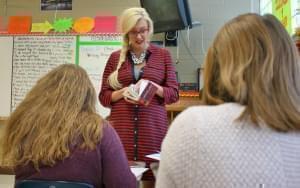 Lindsey Jensen standing in front of two seated students in her classroom