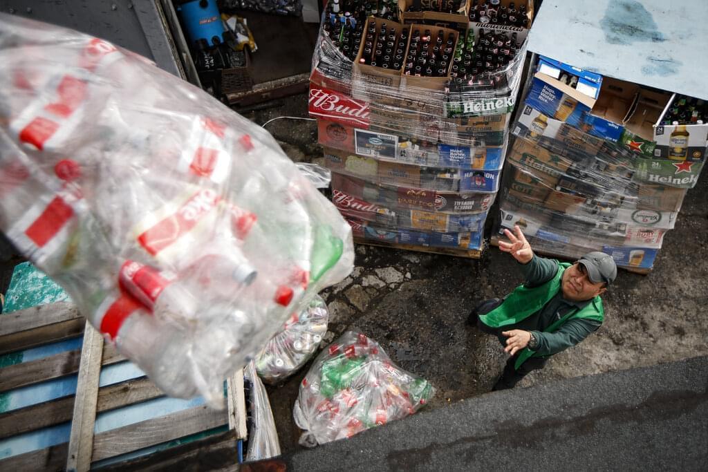 Manuel Rene Del Carmen organizes bags of recyclables and throws them into their allotted storage spaces at the Sure We Can recycling depot, Thursday, Feb. 27, 2020, in the Bushwick neighborhood of New York.