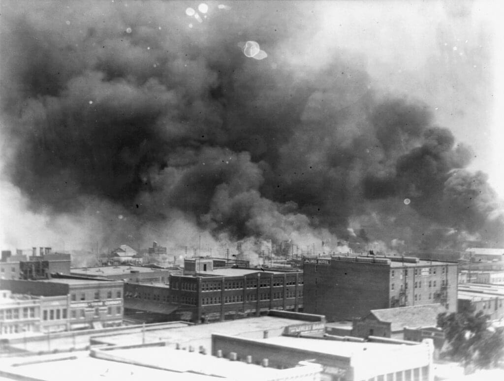 In this 1921 image provided by the Library of Congress, smoke billows over Tulsa, Okla. For decades, when it was discussed at all, the killing of hundreds of people in a prosperous black business district in 1921 was referred to as the Tulsa race riot.
