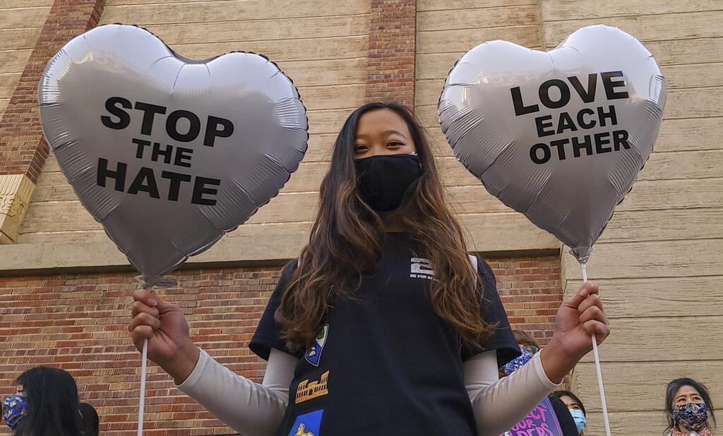 In this March 13, 2021, file photo, Chinese-Japanese American student Kara Chu, 18, holds a pair of heart balloons decorated by herself for the rally