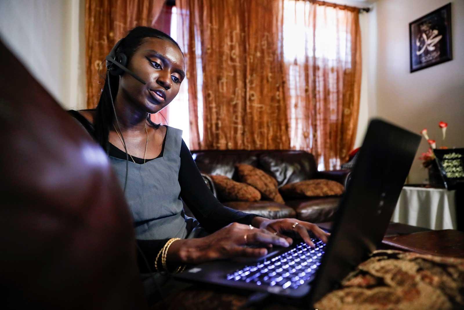 In this Aug. 5, 2020, file photo, Maryama Diaw, a contact tracer with New York City's Health + Hospitals battling the coronavirus pandemic, sets up her remote calling system at her home before reaching out to potential patients, in New York.