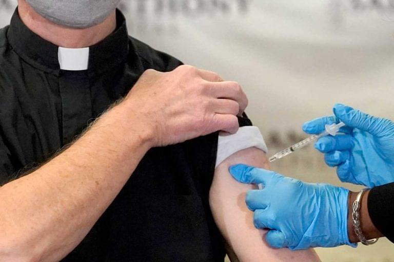 In this Wednesday, Dec. 23, 2020 file photo, a Catholic pastor receives the first of the two Pfizer-BioNTech COVID-19 vaccinations at a hospital in Chicago.