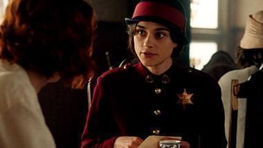 Woman in red jacket and hat with police badge