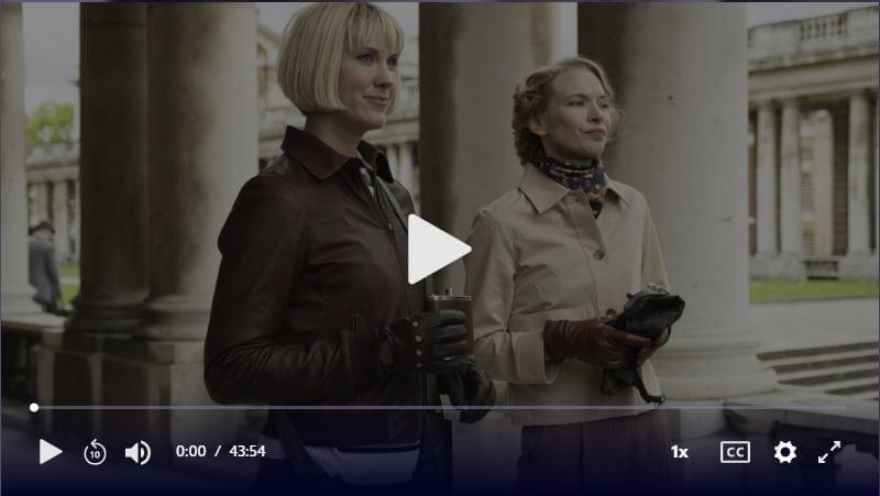 Two women stand outside looking ahead. Click to play video.