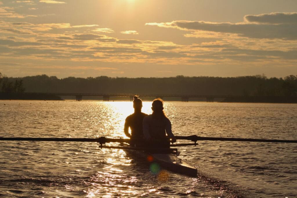 The sun rises over Clinton Lake each morning as the crew unloads the boats to get on the water. The Illini rowing team leaves campus at 4:50 a.m. to get to practice.