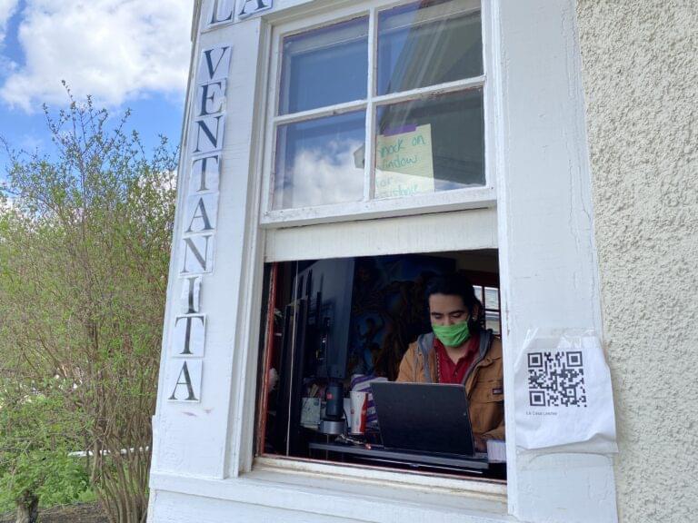 Ricardo Lopez, a junior in food science and human nutrition, works at La Casa to hand out tokens for a free meal at Bevier Cafe.