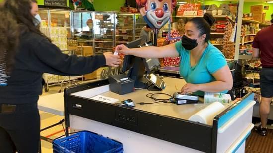 Marly Corado assists a customer at El Progreso Tienda y Carniceria.