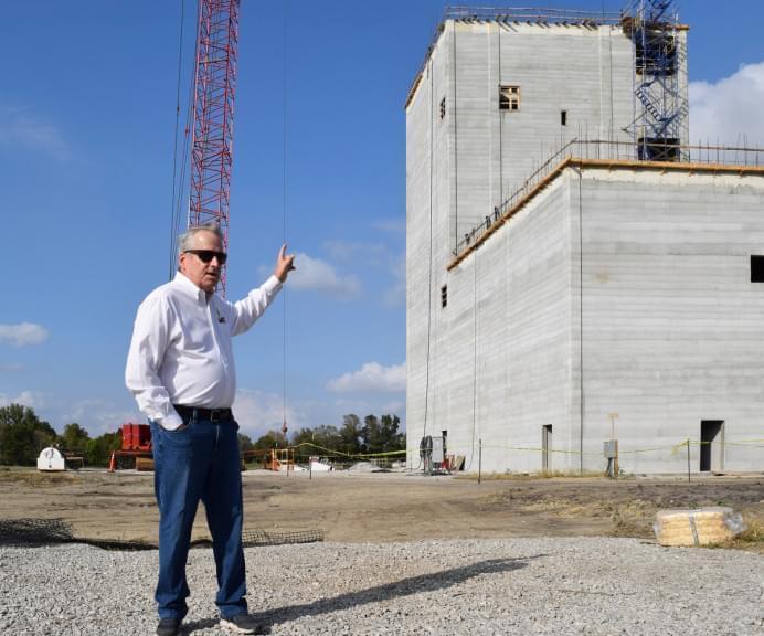 Charles Hurburgh, an agricultural engineering professor at Iowa State University, stands at the site of the Kent Corporation Feed Mill and Grain Science Complex. He points to the feed mill tower, which is more than 100 feet tall. The complex is expected to be completed in fall 2022. It will make feed for livestock and train students who want to work in the feed and grain industry.