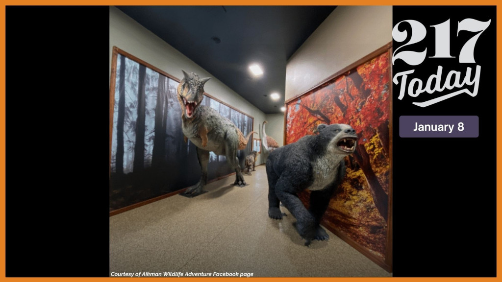 Large statues of prehistoric creatures in a hallway.