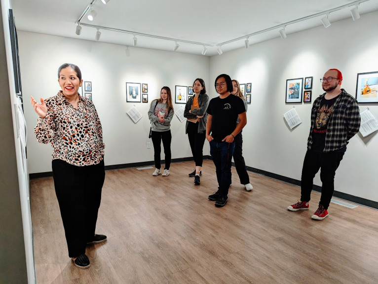 Yolanda Alonso (left) speaks to visitors at Illinois Art Station's We Are The Latinos en BloNo: Our Stories in Words & Photographs exhibit.