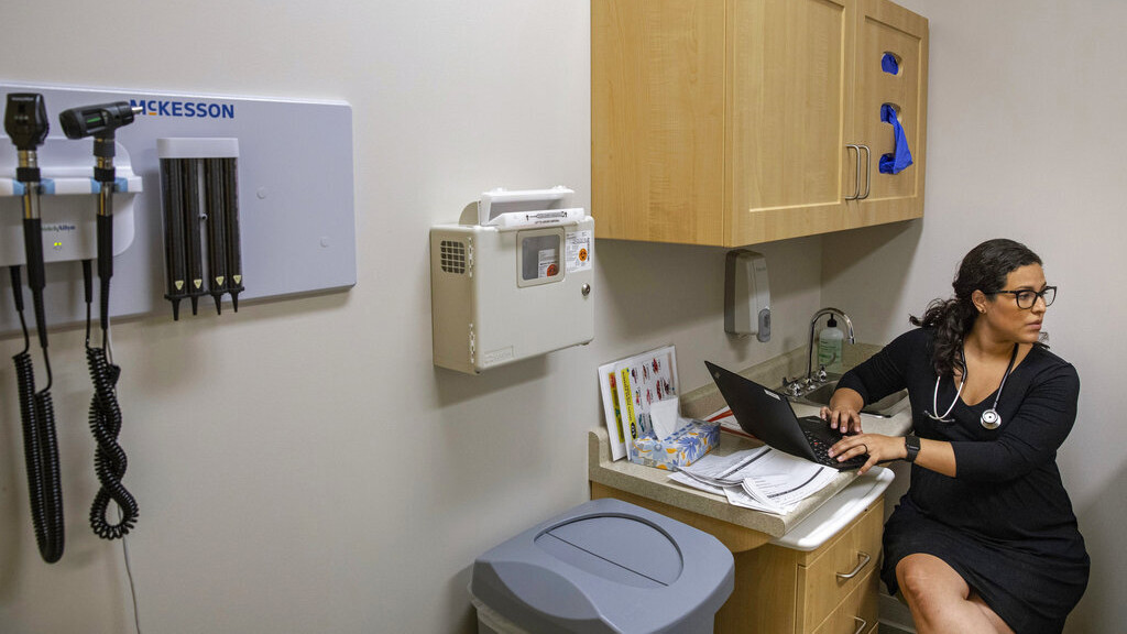 In this Aug. 13, 2019, photo, Jasmine Saavedra, a pediatrician at Esperanza Health Centers in Chicago, talks to patients in her clinic.