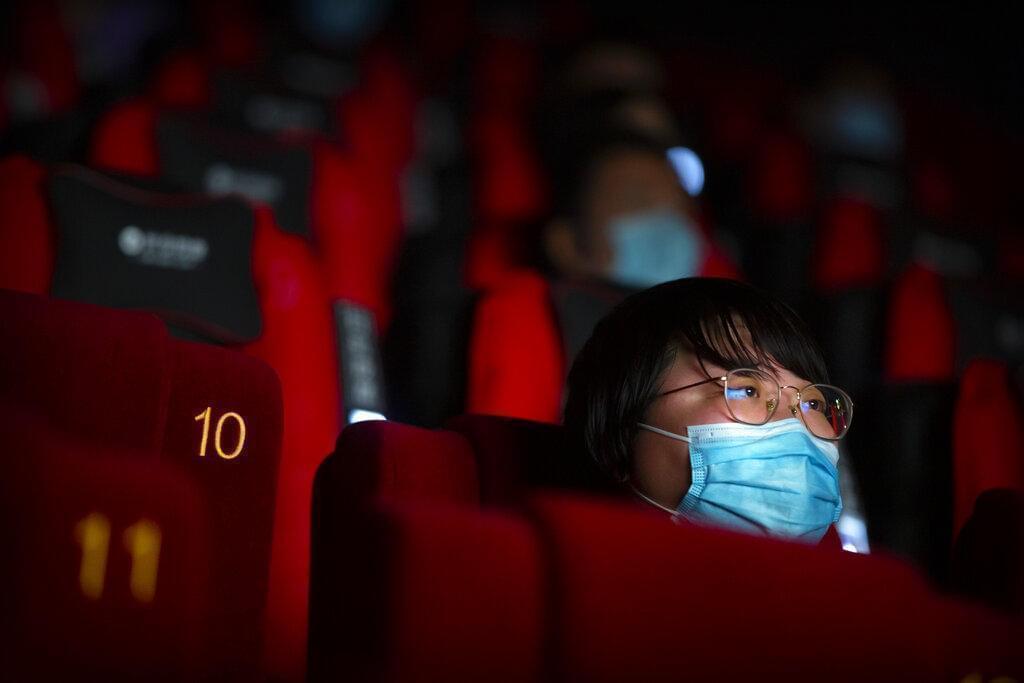 People wearing face masks to protect against the coronavirus watch a film at a movie theater in Beijing, Friday, July 24, 2020. Beijing partially reopened movie theaters as the threat from the coronavirus continues to recede in China’s capital.