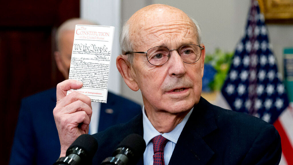 Supreme Court Associate Justice Stephen Breyer holds up a copy of the United States Constitution as he announces his retirement in the Roosevelt Room of the White House in Washington, Thursday, Jan. 27, 2022.