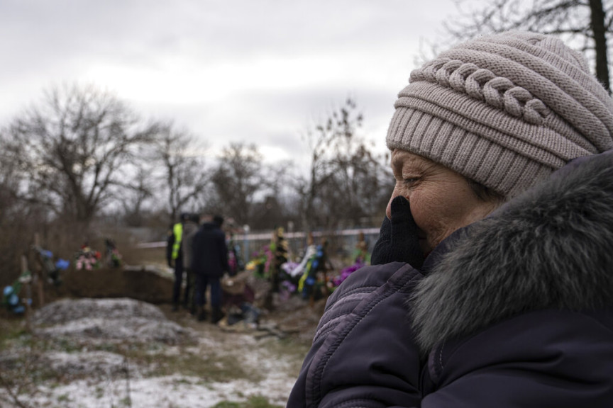 Tamila Pyhyda cries during the exhumation of her husband Serhii Pyhyda who was killed by Russian forces in the recently retaken town of Vysokopillya, Ukraine, Monday, Dec. 5, 2022. Russian invaders left behind all sorts of trickery as they fled the southern city to jubilation across Ukraine a month ago, and continue to strike it from afar. Life in Kherson is still far from back to normal.