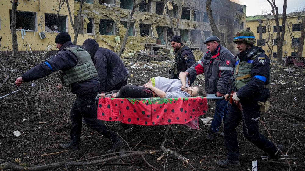 Ukrainian emergency employees and volunteers carry an injured pregnant woman from a maternity hospital damaged by shelling in Mariupol, Ukraine, Wednesday, March 9, 2022.