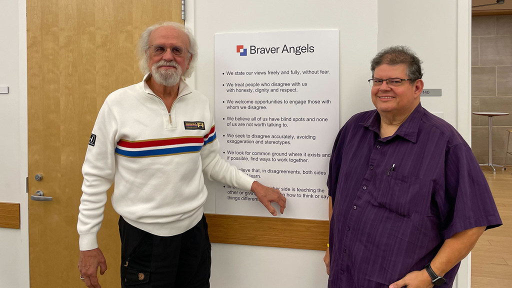 Michael Trout (left), a blue-leaning coach for Braver Angels East Central Illinois Alliance stands next to Tony Schutz (right), a red-leaning coach at the Champaign Public Library for monthly meetup on Sept. 24.