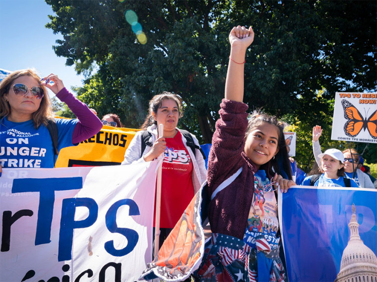 Marilyn Miranda, 12, of Washington raises her hand up during a protest for an extension of the Temporary Protected Status in September 2022 in Washington, D.C.