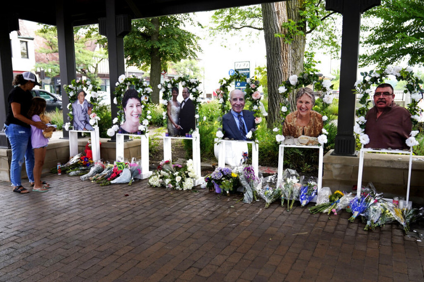 Visitors pay their respects, Thursday, July 7, 2022, at altars for the seven people killed in the Fourth of July mass shooting in Highland Park, Ill. 