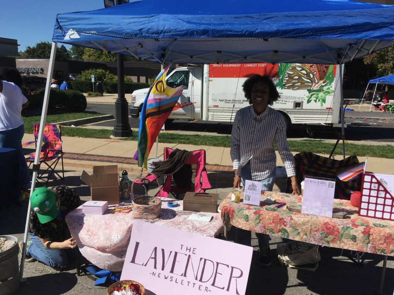 Jada Fulcher, co-founder of the Lavender Newsletter, stands underneath the shade of the newletter's tent at C-U PrideFest on Oct. 2 in downtown Urbana. Fulcher said the newsletter's debut at the fair was well-received by community members. 