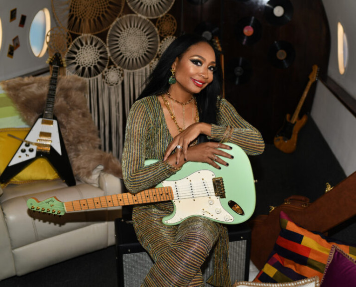 Malina Moye holding her signature upside down left handed guitar 