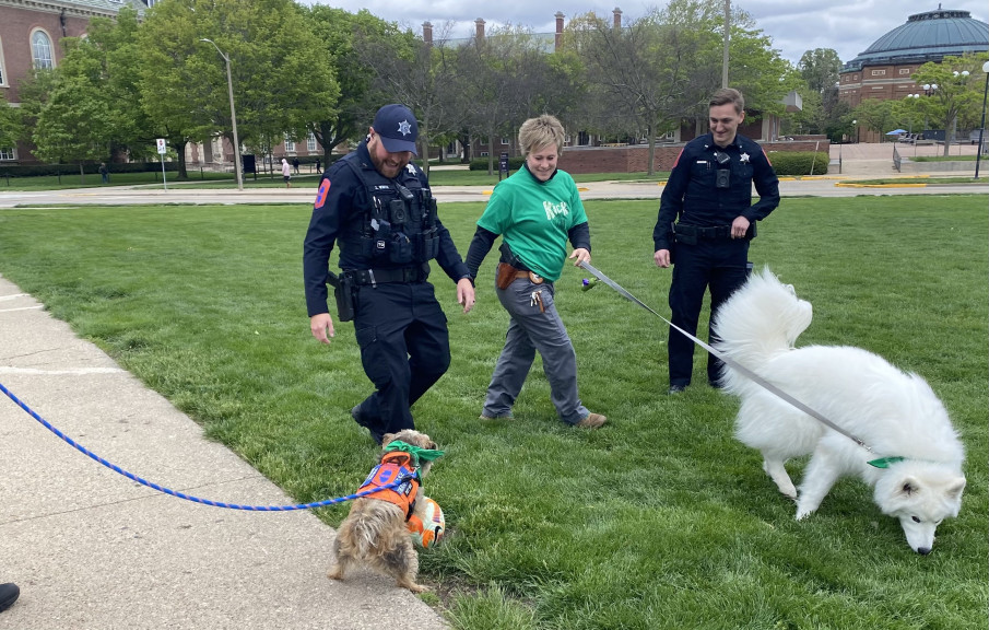 University of Illinois Officer Zachary White, Detective Tara Hurless and Officer Joshua Fisher play with therapy K-9s Rosie and Kirby at the “Kick the Stigma” event on May 1. UIUC utilizes therapy dogs at community events as a part of its REACH program. 