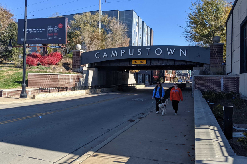  Students walking their dog in front of the Campustown bridge in Champaign on Nov. 14. Many off-campus apartments are located in Campustown.