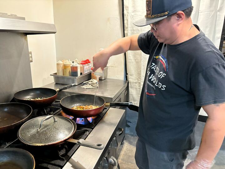 Co-owner of A Taste of Both Worlds Raz Diaz cooks pancit, a popular dish at his restaurant, which features Filipino and Cambodian fusion.