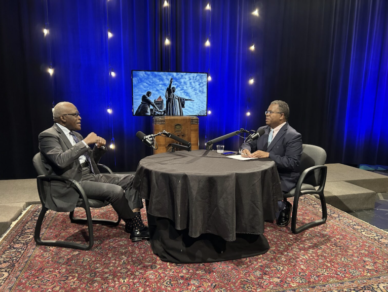 L to R: Chancellor Robert Jones and IPM News Director Reginald Hardwick seated at table.