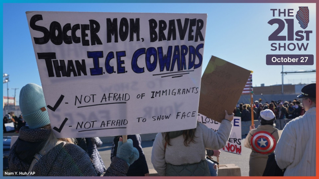 protesters are seen from behind dressed for cold weather and holding signs, including one that reads