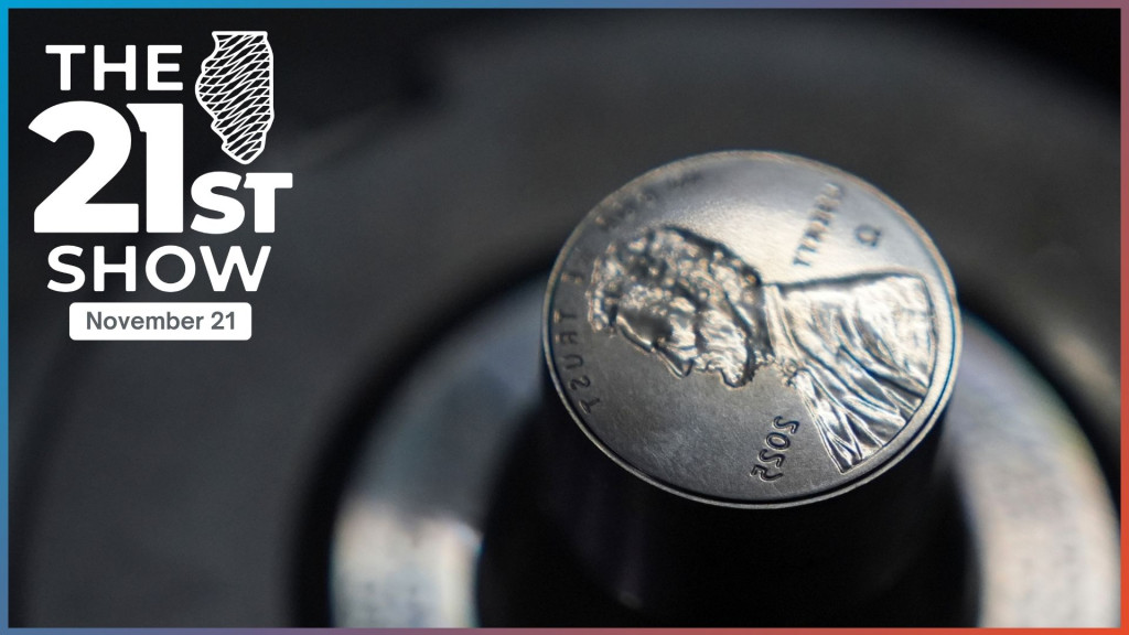 A dark gray cylinder of metal ends with the reverse image of the penny — the profile of Abraham Lincoln, plus LIBERTY, IN GOD WE TRUST, 2025, and the Greek letter omega.