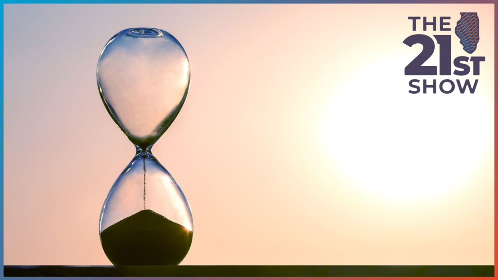 an hourglass has run out of time; in the background the sun is low to the horizon