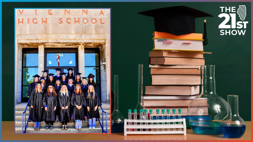 a group of high school students poses in cap-and-gown in front of a building with 
