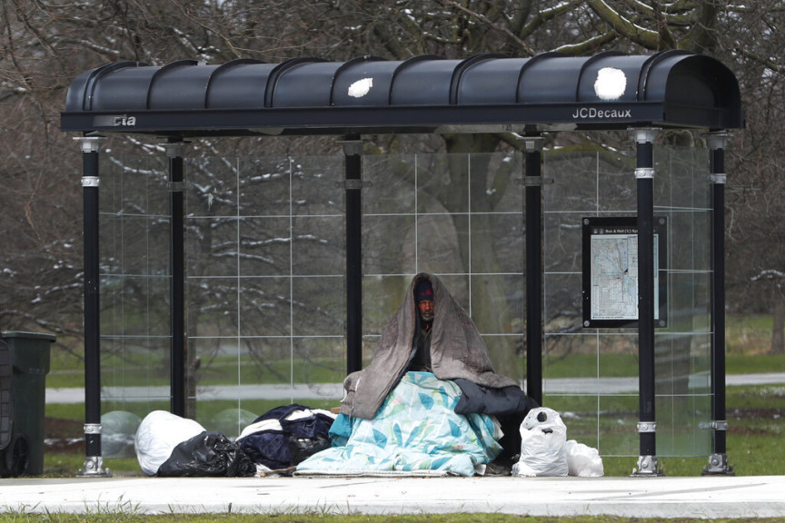 A homeless man occupies a Chicago Transit Authority bus shelter. 