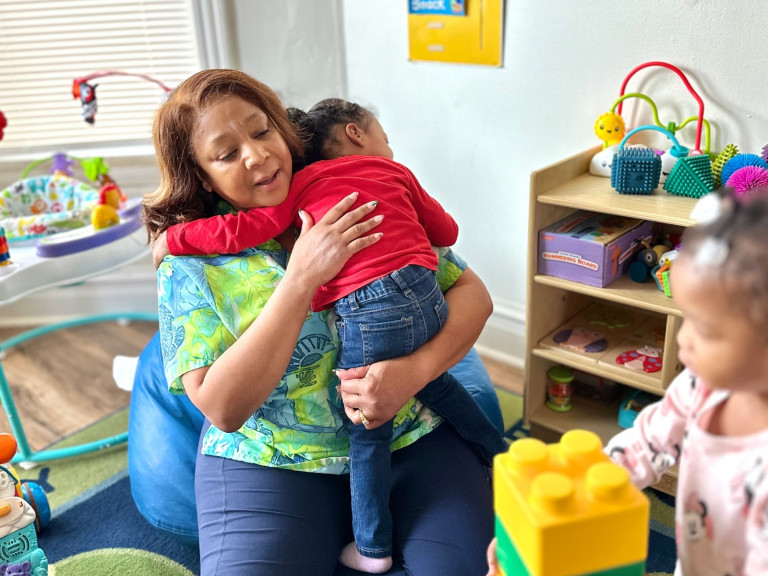 Bridgett Vance, a home-based daycare provider in Chicago's Chatham neighborhood, comforts a child. Vance is one of more than 15,000 home-based daycare providers in Illinois’ Child Care Assistance Program negotiating a contract with the state over pay and benefits.