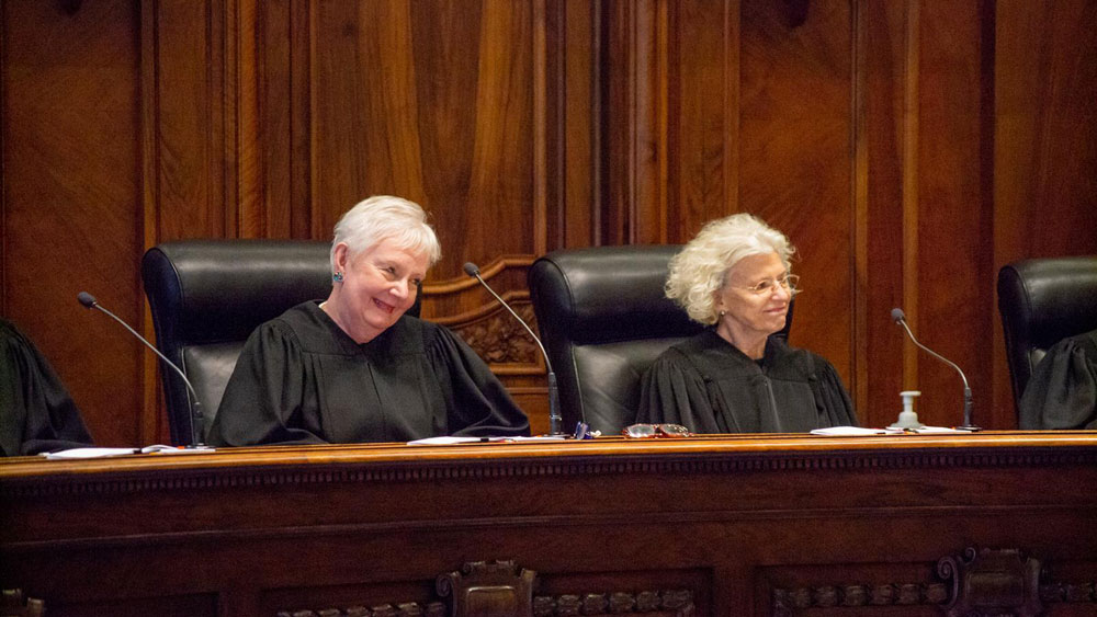 Chief Justice Mary Jane Theis (left) is pictured with outgoing Chief Justice Anne M. Burke. Both are Democrats. 