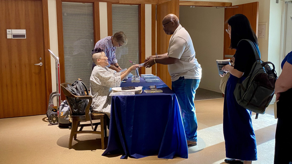 traci kato-kiriyama interacts with an audience member after their talk at the Spurlock Museum on Thursday, Sept. 26. She signed copies of her book, “Navigating With(out) Instruments.