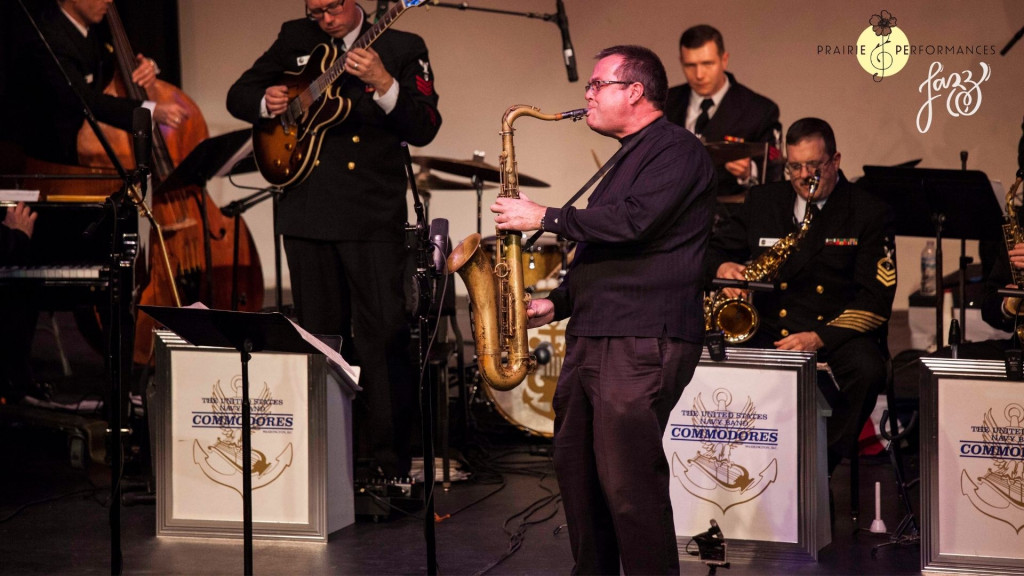 Saxophonist Chip McNeill plays in front of members of the U.S. Navy Band