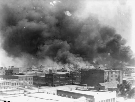 In this 1921 image provided by the Library of Congress, smoke billows over Tulsa, Okla. For decades, when it was discussed at all, the killing of hundreds of people in a prosperous black business district in 1921 was referred to as the Tulsa race riot. 