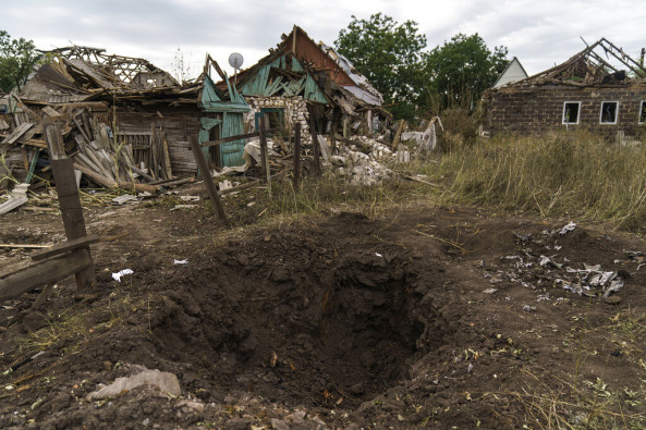 A crater from a Russian rocket attack is seen next to damaged homes in Kramatorsk, Donetsk region, eastern Ukraine, Saturday, Aug. 13, 2022. The strike killed three people and wounded 13 others, according to the mayor. The attack came less than a day after 11 other rockets were fired at the city, one of the two main Ukrainian-held ones in Donetsk province, the focus of an ongoing Russian offensive to capture eastern Ukraine's Donbas region.