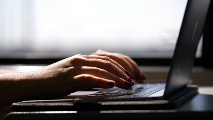 A woman types on a laptop while on a train in New Jersey, May 18, 2021. A new study from Northwestern University examined whether people expressing anger on social media were as upset as they professed to be in their posts.