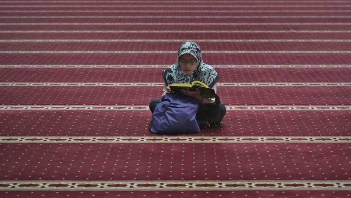 A woman reads the Qu'ran during Ramadan, a holy month in the Muslim calendar.