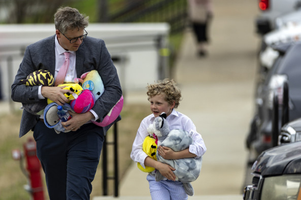 A man and young boy carrying several plush toys leave the funeral service held for The Covenant School shooting victim Evelyn Dieckhaus at the Woodmont Christian Church Friday, March 31, 2023, in Nashville, Tenn. The toys were donated by an anonymous donor for all the children in attendance.
