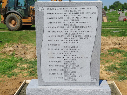 In this June 10, 2015 photo, a newly installed burial marker at the city cemetery in Herrin, Ill. displays the names of 17 victims of the 1922 Herrin Massacre. The clash between striking coal miners and a group of replacement workers and guards in southern Illinois was one of the nation’s deadliest labor disputes A team of local historians and university scientists spent several years working to identify the location of the previously unmarked graves. 