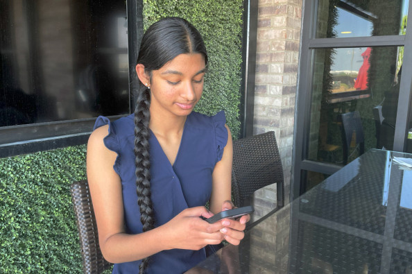 Shreya Nallamothu looks at her phone in Bloomington, Ill., on Tuesday, May 9, 2023. Lawmakers made Illinois the first in the country to create protections for child social media influencers. Nallamothu, 15, raised her concerns to Illinois state Sen. David Koehler of Peoria, who then set the legislation in motion.